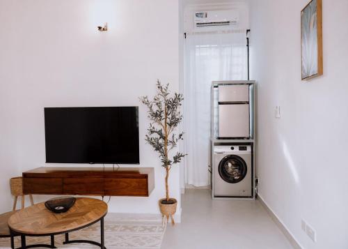 a living room with a flat screen tv on a wall at Magnolia Homes Tz in Nkunjila