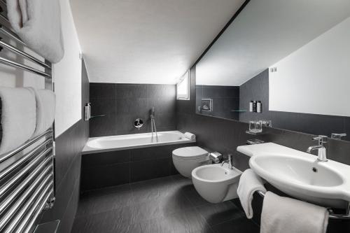 a black and white bathroom with a sink and a toilet at LHP Hotel Montecatini Palace & SPA in Montecatini Terme