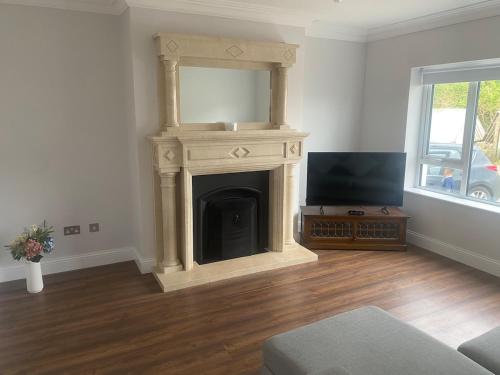 a living room with a fireplace and a tv at Spacious 5 bedroom house in Buncrana in Buncrana
