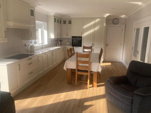 a kitchen with a table and chairs and a couch at Spacious 5 bedroom house in Buncrana in Buncrana