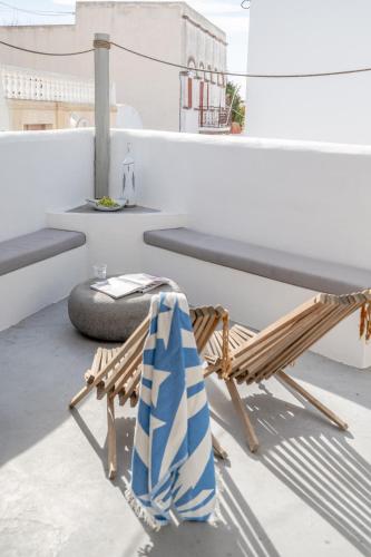 a chair with a towel sitting on a balcony at Kampanario Luxury Two-Bedroom Villa with Private Jacuzzi in Megalokhori