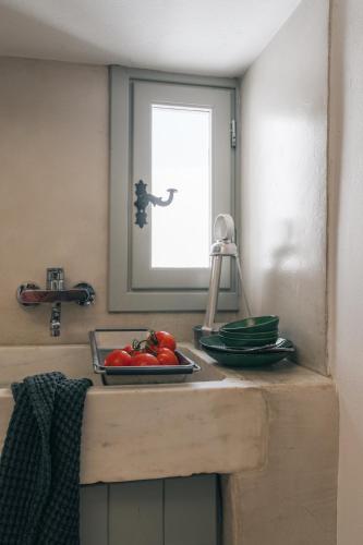 a kitchen counter with a plate of tomatoes on it at Kampanario Luxury Two-Bedroom Villa with Private Jacuzzi in Megalokhori