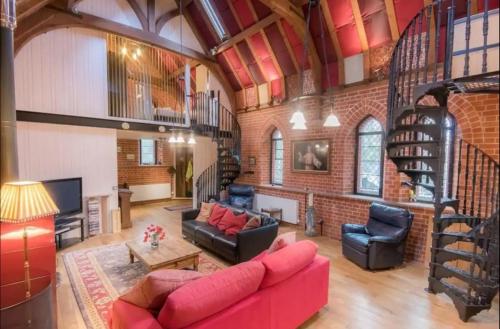 sala de estar con sofá rojo y pared de ladrillo en Curbridge Chapel, en Southampton