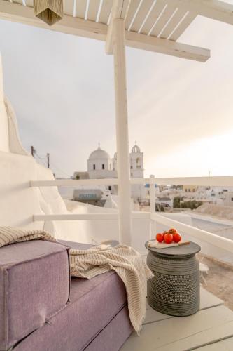 a purple couch on a porch with a table with tomatoes on it at Yposkafon Concept Two-Bedroom Villa with Private Jacuzzi and Hamam in Megalokhori