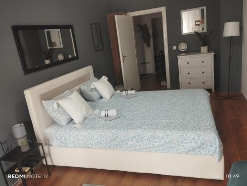 a bedroom with a bed with a blue comforter at Centar Novi Sad in Novi Sad