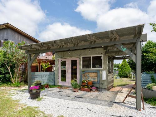 a house with a pergola in the yard at Tabist Elias Garden in Ichinomiya