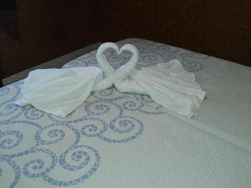 two swans made out of towels on a bed at Pensión Mar in Portomarin