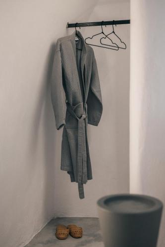 a robe hanging on a wall next to some shoes at Yposkafon Concept Two-Bedroom Villa with Private Jacuzzi and Hamam in Megalokhori
