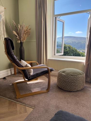 a rocking chair in a living room with a window at Bryn Melyn Apartments in Barmouth
