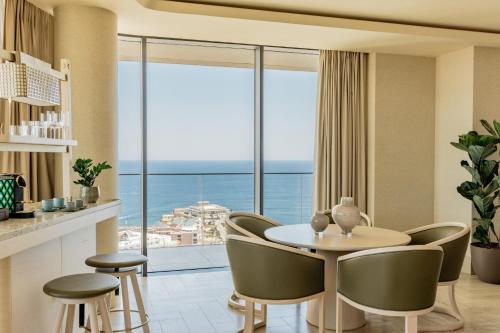 a dining room with a table and chairs and a large window at ME Malta by Meliá in St Julian's