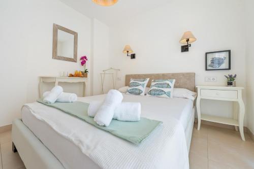 Un dormitorio blanco con dos camas y un espejo. en Apartamento Sf1, en L'Ametlla de Mar