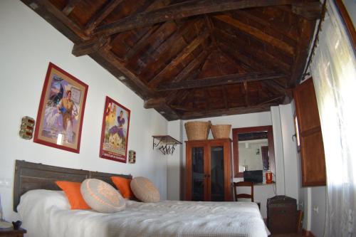 a bedroom with a bed with a wooden ceiling at Apartamentos Carmen de Ramilla in Granada