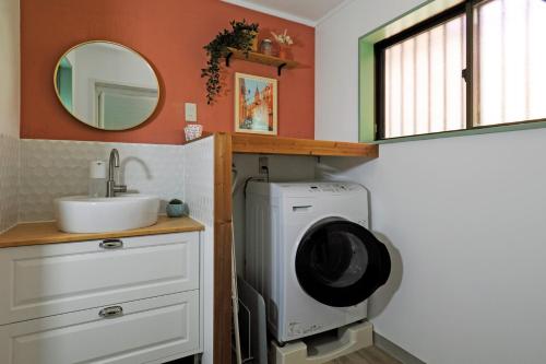 a bathroom with a washing machine and a sink at La maison du sud d'awaji in Minamiawaji