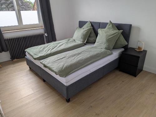 a bed with green pillows at Ferienwohnung Altstadt Lemgo in Lemgo