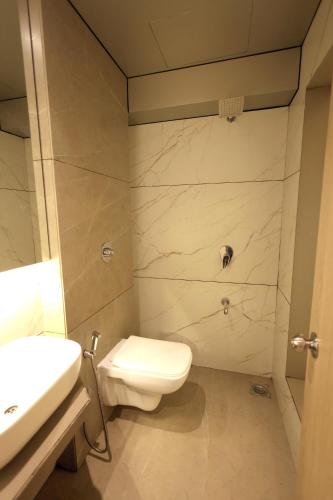 a bathroom with a toilet and a sink at Hotel AR Inn in Thane