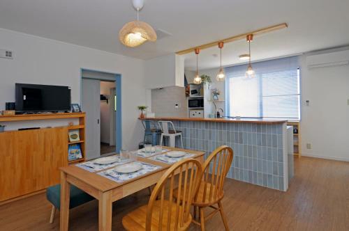 a dining room and kitchen with a table and chairs at La maison du sud d'awaji - Ocean View Private Villa in Minamiawaji