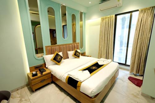 a bedroom with a bed and a large window at Hotel AR Inn in Thane