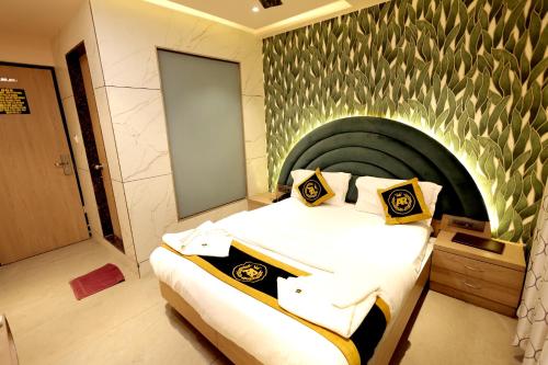 a bedroom with a large bed with a green wall at Hotel AR Inn in Thane