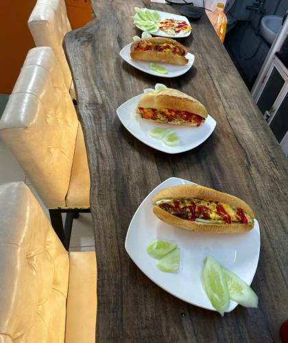 three plates of hot dogs on a wooden table at Viet Vintage Hostel n Pub - Soft mattress - Free Breakfast in Hanoi