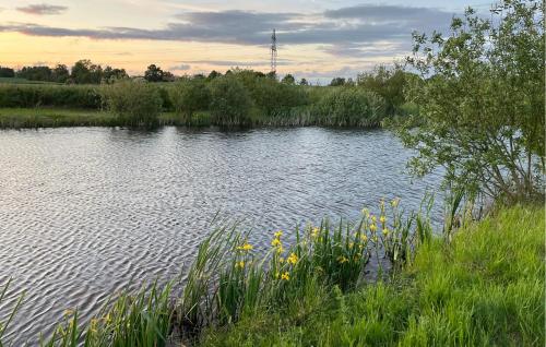 a body of water with some grass and flowers at 2 Bedroom Stunning Apartment In Vellinge in Malmö