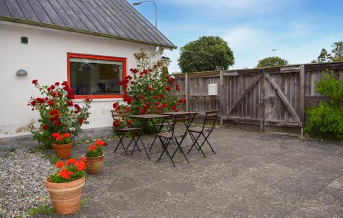 a patio with a table and flowers and a fence at Cozy Home In Smygehamn With Wifi in Smygehamn