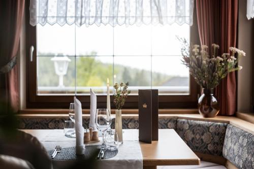 a dining table with wine glasses and a window at Naturhotel Miraval in Perca