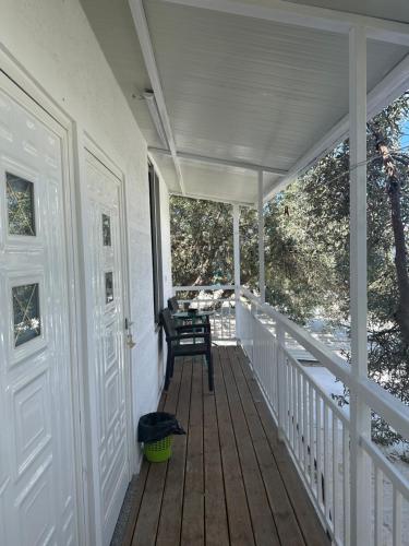 a porch with a bench and a chair on it at SEA bed and restaurant 2 in Borsh