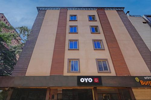 a tall building with a sign in front of it at Hotel O PMR Hotel in Bengaluru