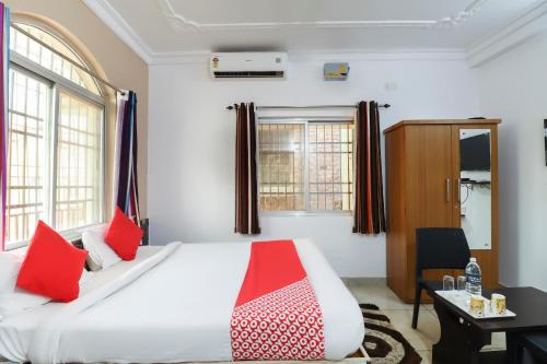 a bedroom with a large white bed with red pillows at Super Capital O The Tulip in Rānchī