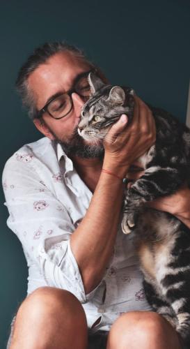 a man in glasses is holding a cat at La Moustache Bleue in Bouin