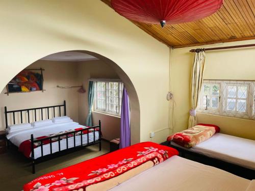 two beds in a room with an arched doorway at Grymsby Holiday Bungalow in Nuwara Eliya