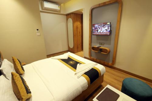 a hotel room with a bed and a tv at Hotel AR Inn in Thane