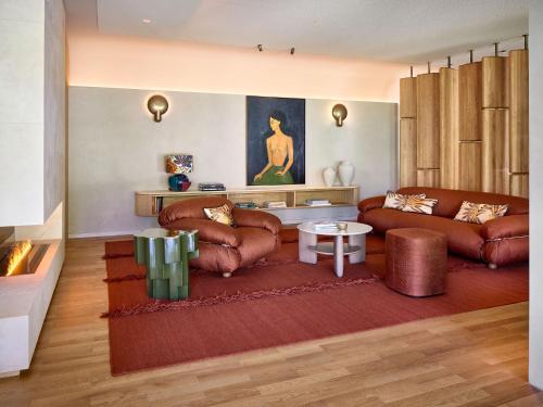a living room with two leather couches and a table at LA MAISON hotel & spa in Saarlouis
