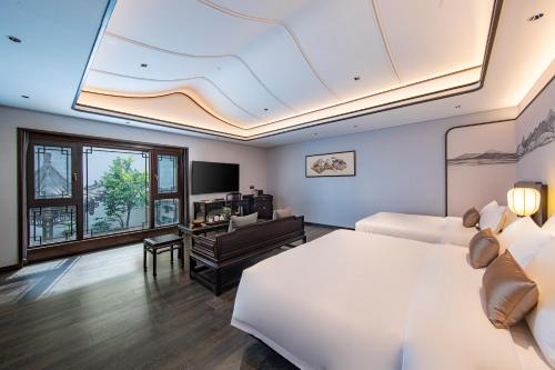 a bedroom with a large bed and a living room at 福州三坊七巷三宝宾邸 in Fuzhou