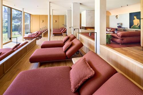 a living room with red furniture and windows at LA MAISON hotel & spa in Saarlouis