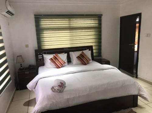 a bedroom with a large bed with white sheets and pillows at Mende Hotel in Lagos