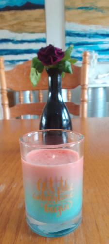a glass with a flower in a vase on a table at Malin Head SolasTobann ArtHouse Room 1 En-suite in Malin Head