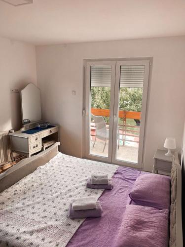 a bedroom with a bed with two towels on it at Apartmani Ana S in Vrnjačka Banja