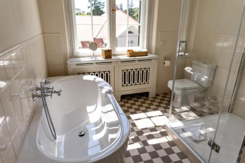 a bathroom with a tub and a toilet at Schlosshotel Neustrelitz in Neustrelitz