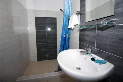 a bathroom with a white sink and a shower at Waterfront Apartments in Tisno