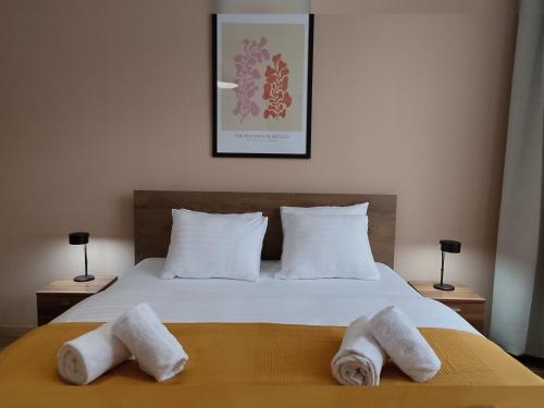 a bedroom with a bed with two towels on it at Corvin Center Suites in Budapest