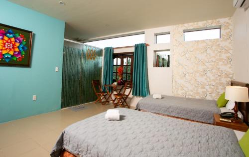 two beds in a room with blue walls at Cat Tien Jungle Lodge in Cat Tien