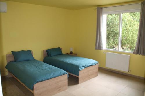 una camera da letto con due letti e una finestra di Au bord du Rhône a Tain-l'Hermitage
