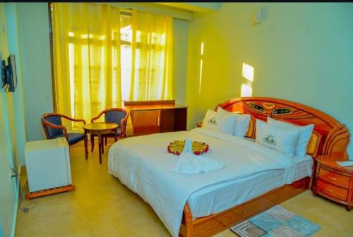 a bedroom with a bed and a table and chairs at New Tourist Hotel in Mwanza
