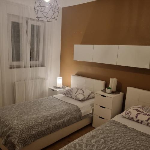 a bedroom with two twin beds and a window at Superior apartment Nina in Povljana