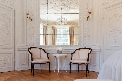 two chairs and a table in a room with a window at Schlosshotel Neustrelitz in Neustrelitz