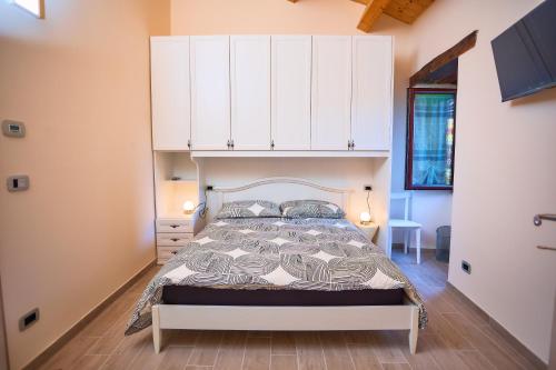 a bedroom with a bed with white cabinets above it at Oleum Guest House in Mirabello Sannitico