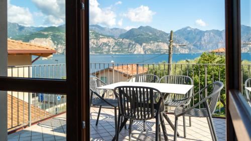 a table and chairs on a balcony with a view of the water at June Stay Lake Garda in Brenzone sul Garda