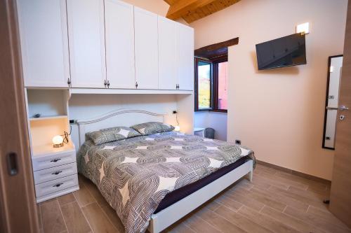 a bedroom with a bed and a tv on the wall at Oleum Guest House in Mirabello Sannitico