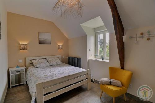 a bedroom with a bed and a yellow chair at La ville es brets in Saint-Jouan-des-Guérets
